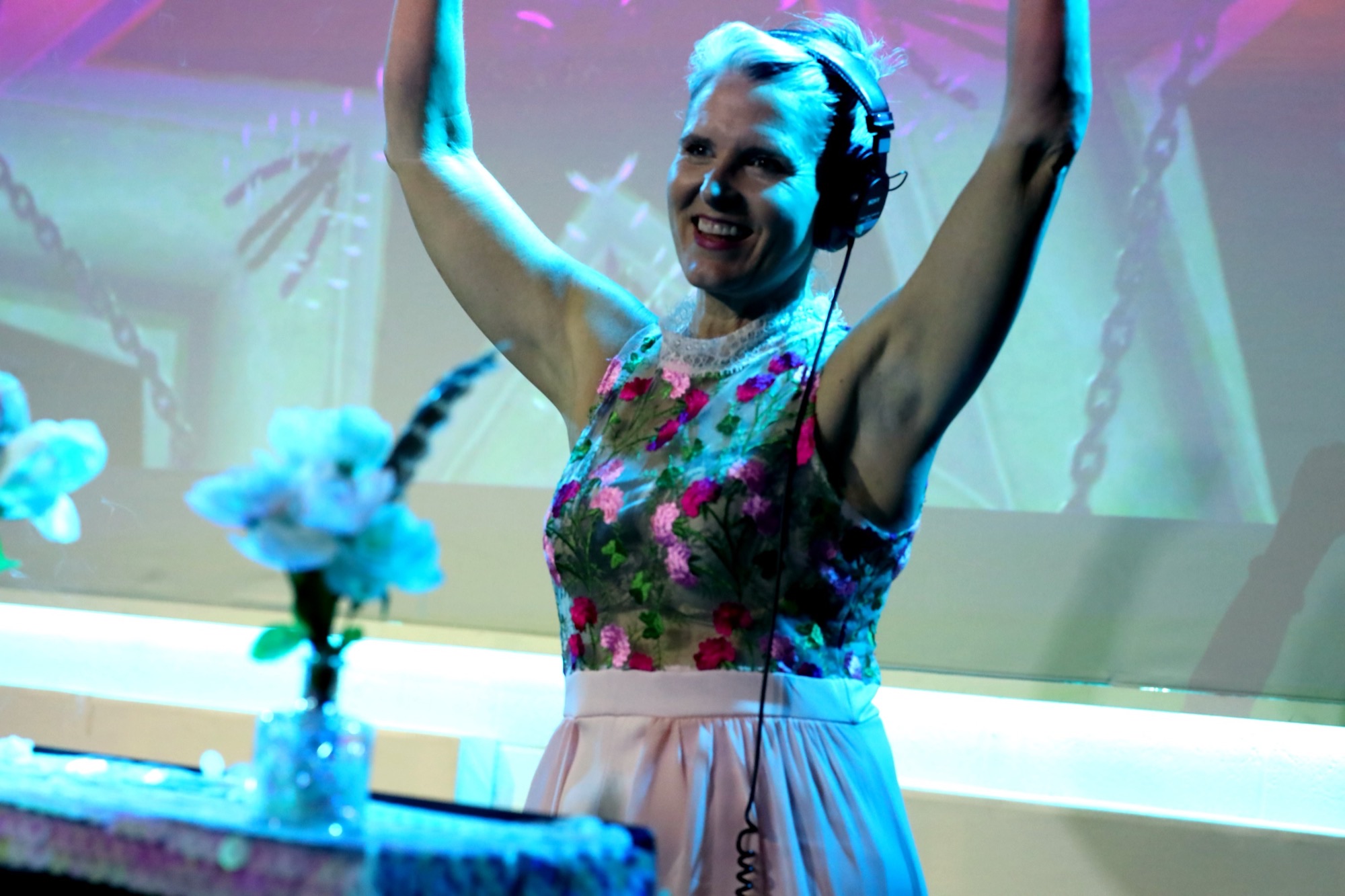Jess Miller DJing with her arms raised at Best. Day. Ever!